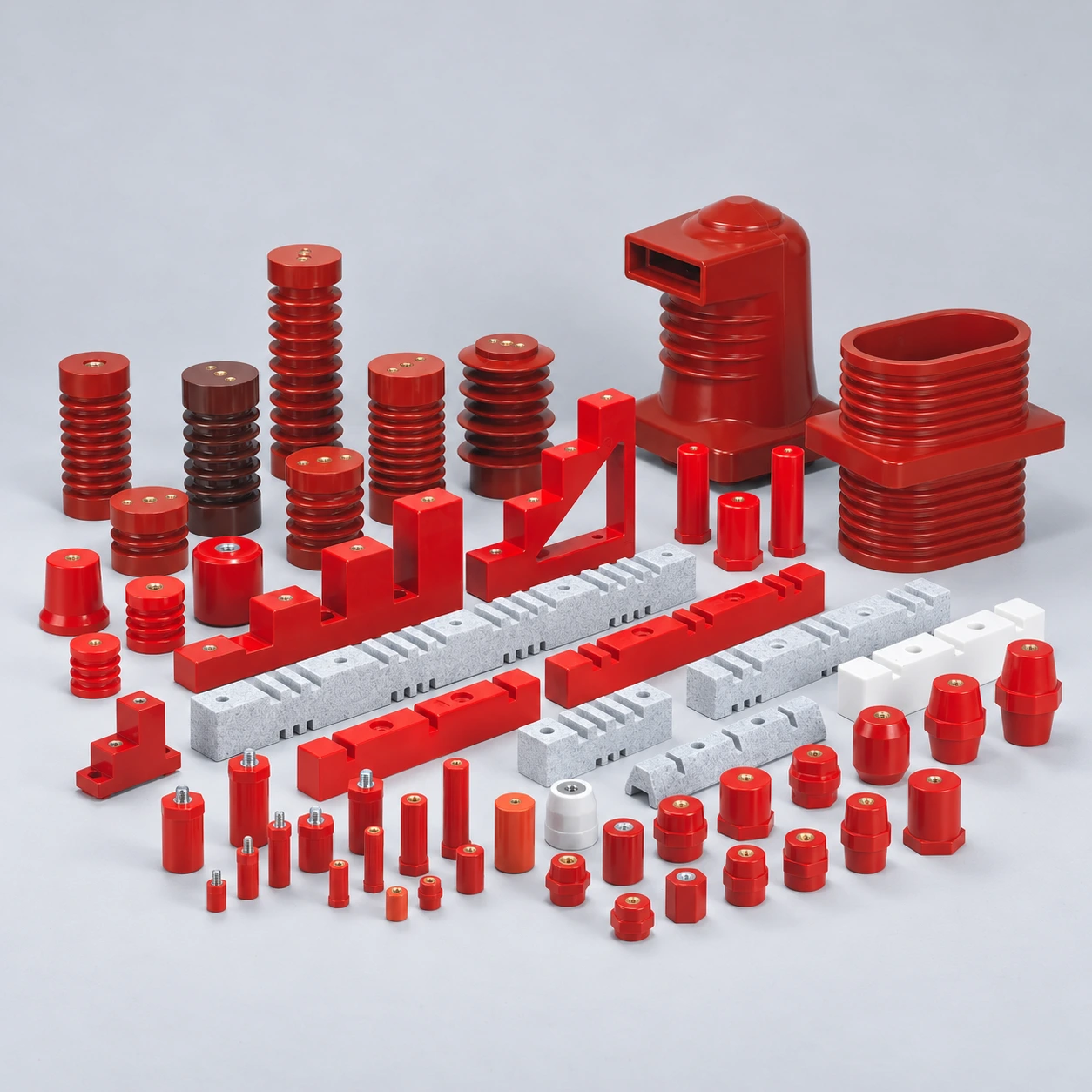 Red and brown busbar support insulators, stepped supports and grooved support components on a light studio background